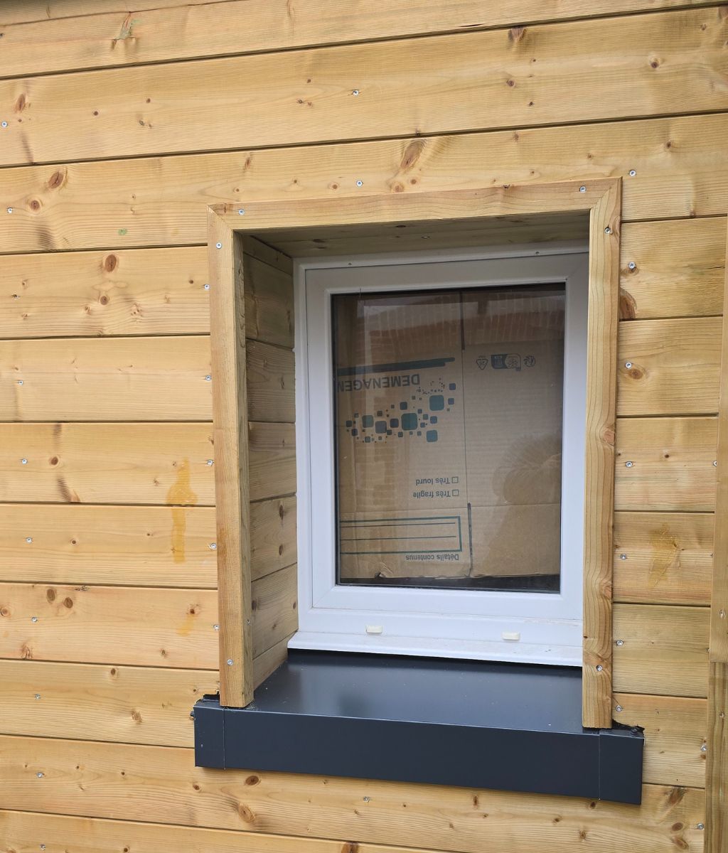 Installation de bardage bois sur mesure et isolation de façade par SF Toiture à Messery, Yvoire et Nernier. Finition moderne de fenêtre sur construction neuve.