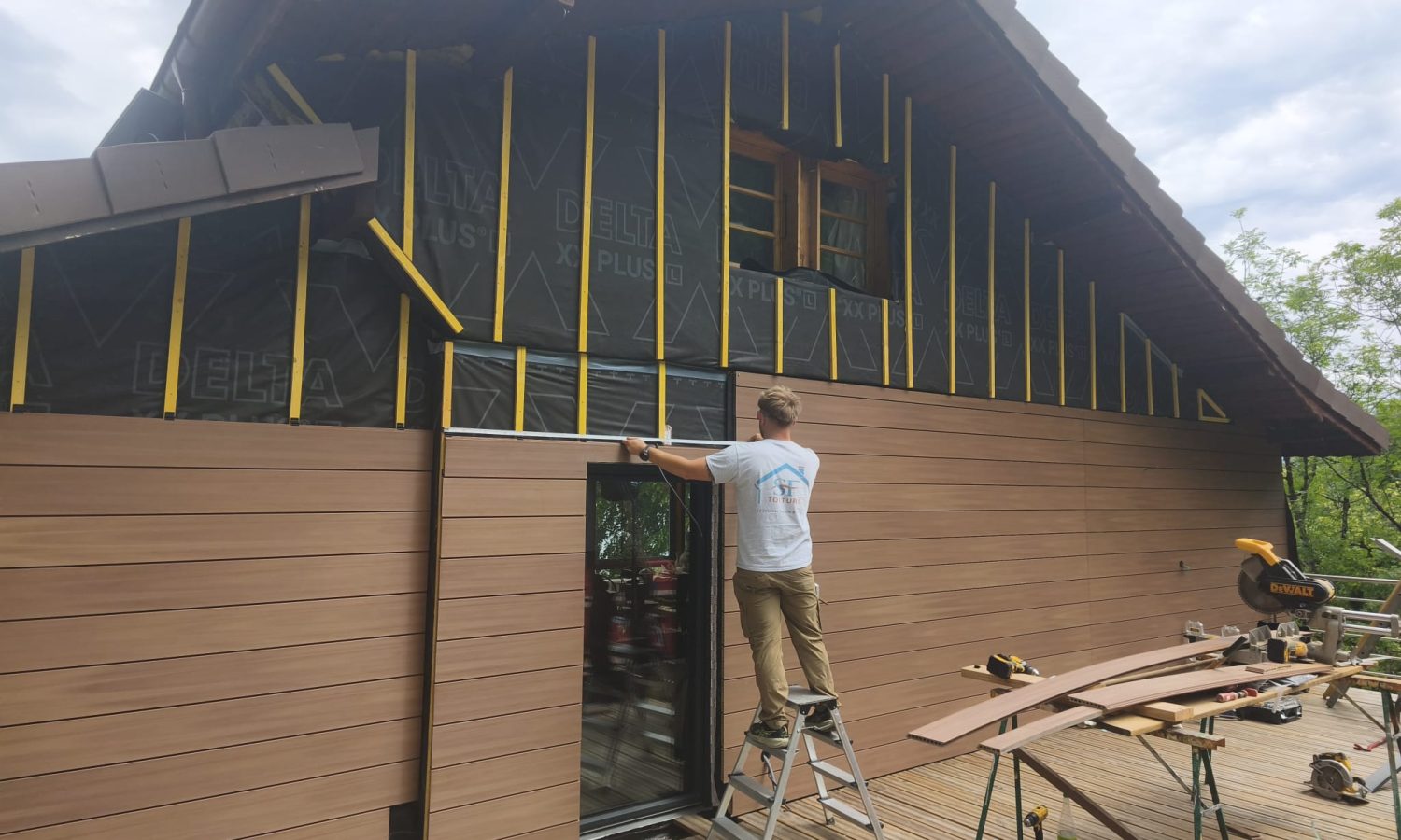Pose en cours de bardage composite Silvadec Atmosphère 175 brun soleil par l'entreprise SF Toiture sur un chalet en Haute-Savoie.